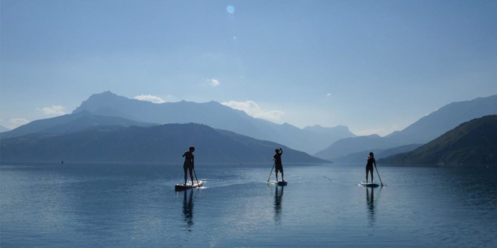 trois personnes font du paddle sur le lac de Serre-Ponçon