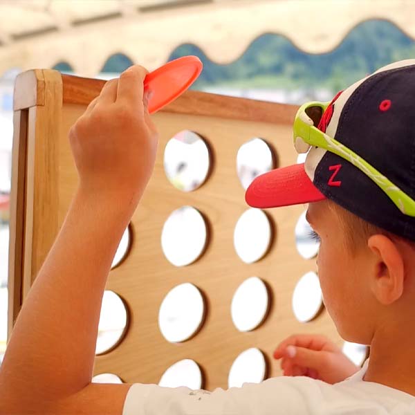 un petit garçon joue avec un jouet en bois au festival l'Echo des mots