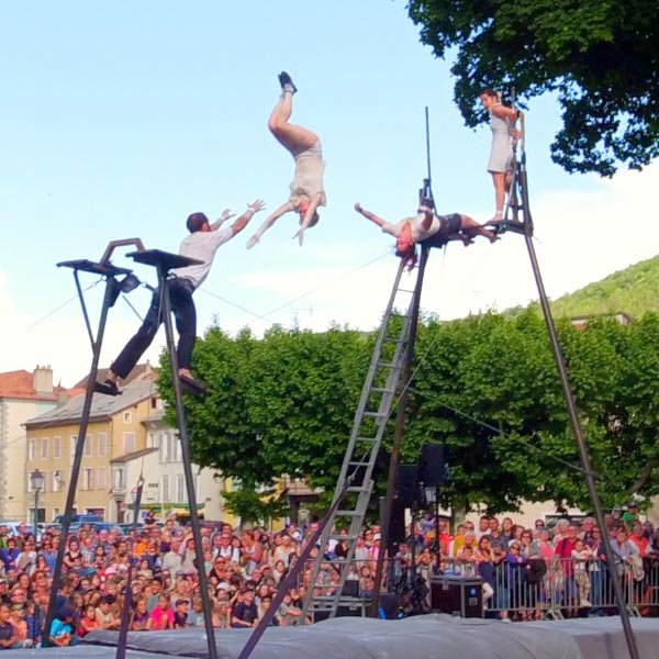 quatre acrobates effectuent des sauts lancés et portés dans les airs