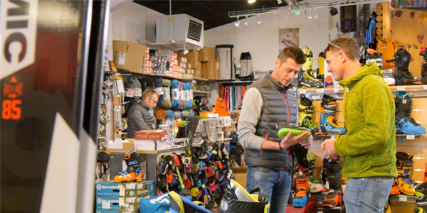 un employé renseigne un client sur des chaussures dans un magasin Approach