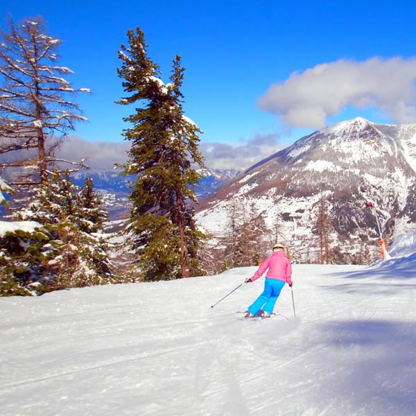 une skieuse descend une piste de ski aux Orres