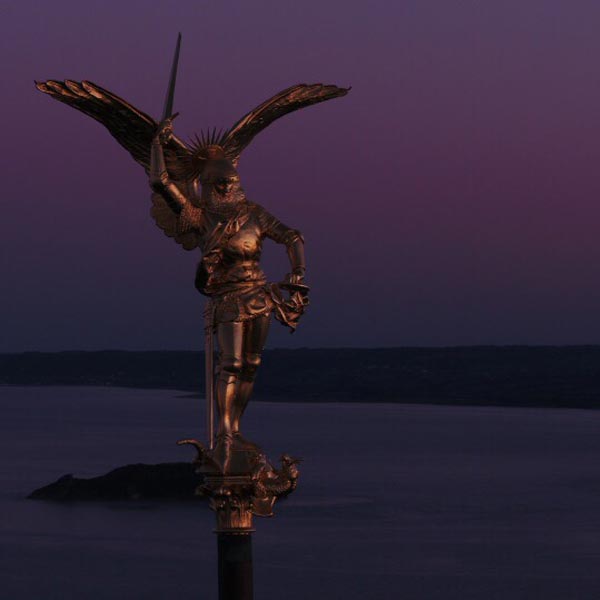 la statue de l'archange saint Michel au sommet de l'abbaye du Mont saint Michel, au crépuscule