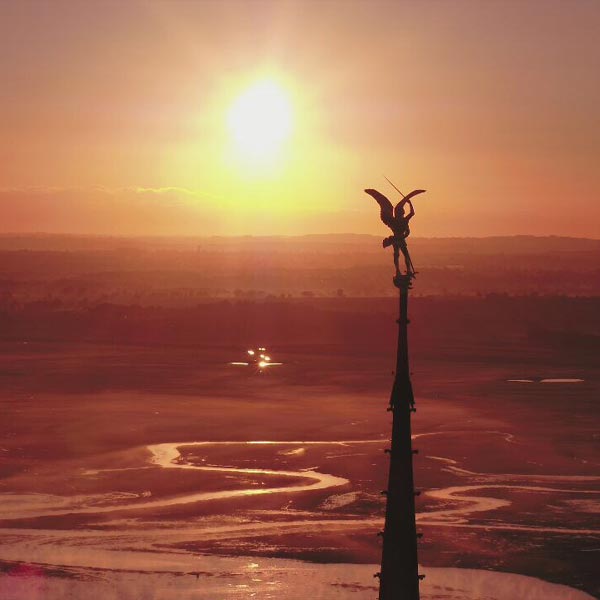 flèche de l'abbaye du mont saint Michel au coucher du soleil